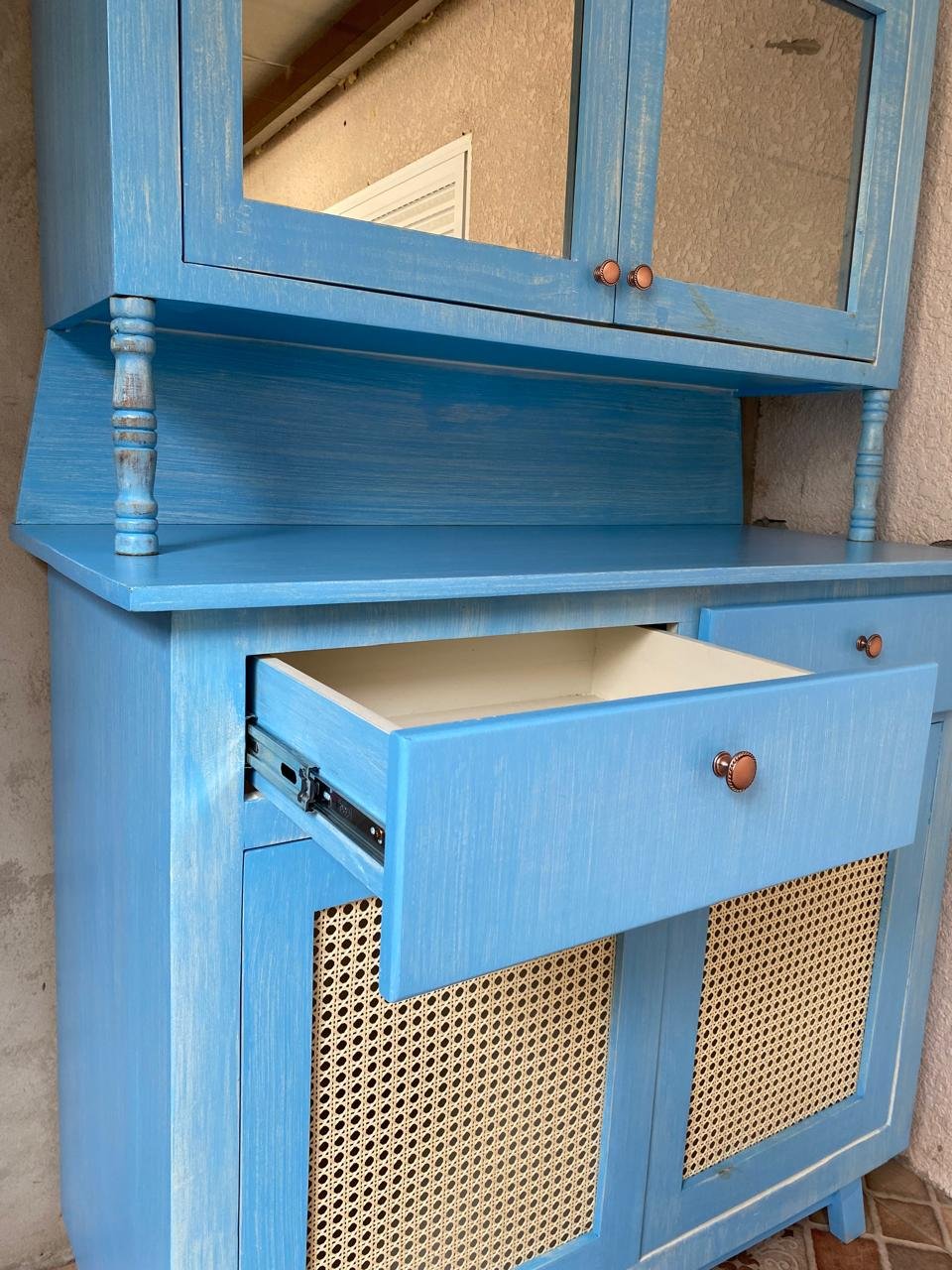 A cristaleira azul — Uma cristaleira e uma mesa herdadas da bisavó do cliente, restauradas para ocupar o canto novo da casa onde a família passou a se reunir.